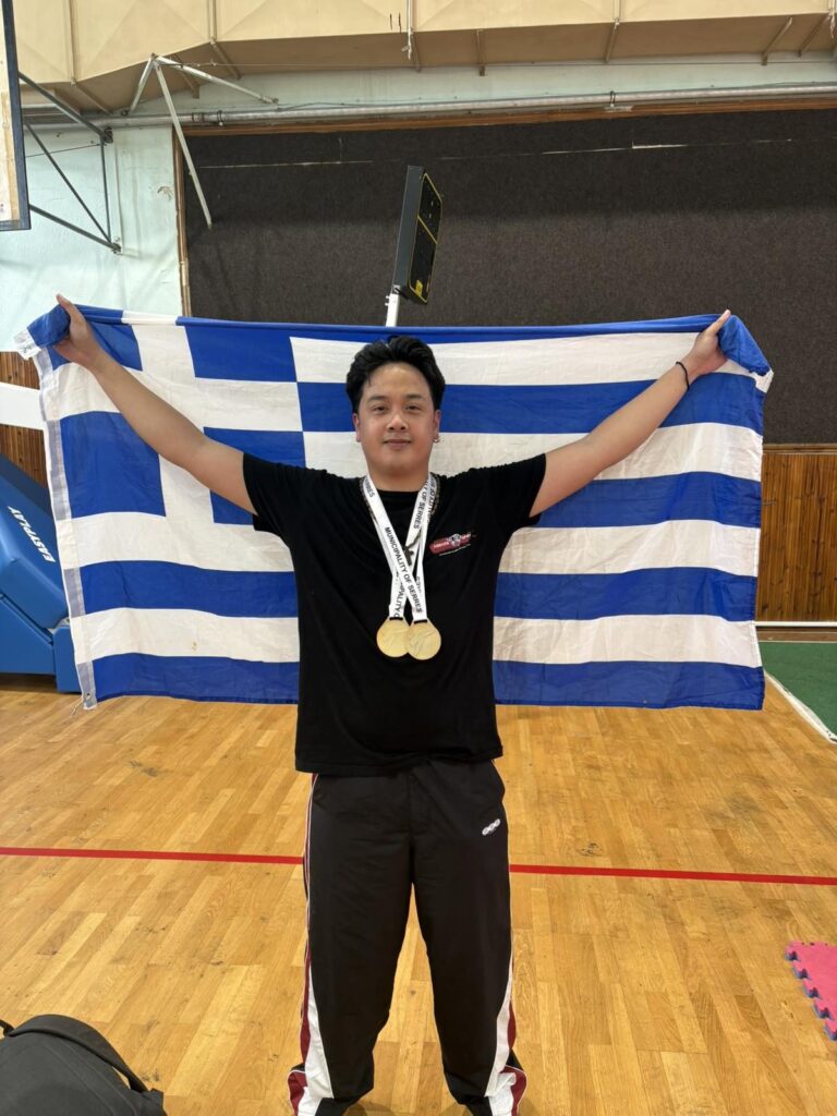 Αθλητής του Fighting Spirit με δύο χρυσά μετάλλια μπροστά στην ελληνική σημαία