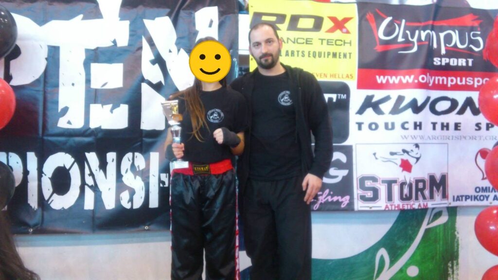 Αθλήτρια του Fighting Spirit με κύπελλο, μαζί με τον προπονητή, σε Open Championship