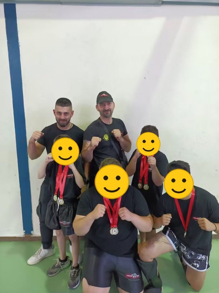 Νεαροί αθλητές του Fighting Spirit με τα μετάλλιά τους και τους προπονητές